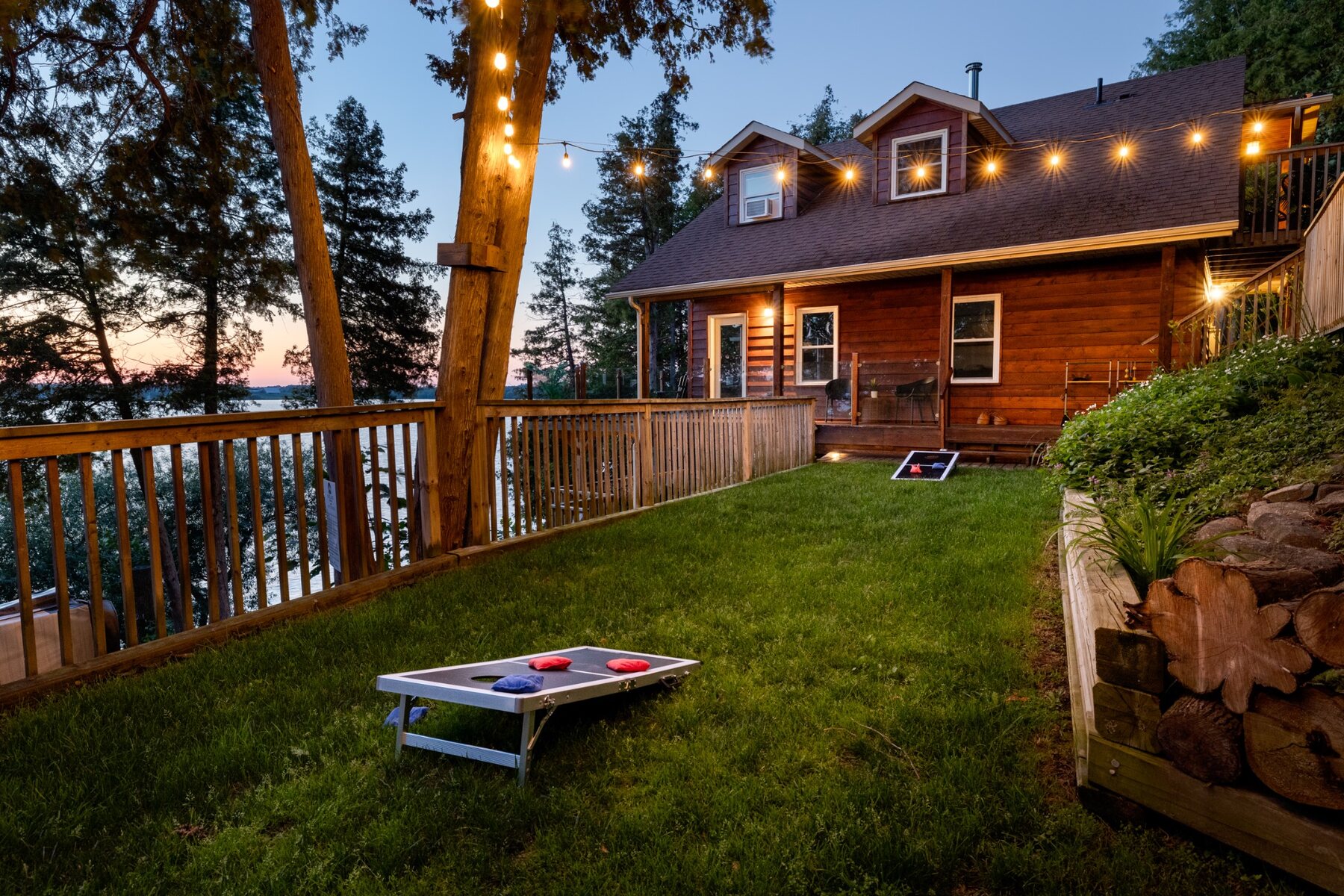 Cottage yard at dusk with string lights and lawn games